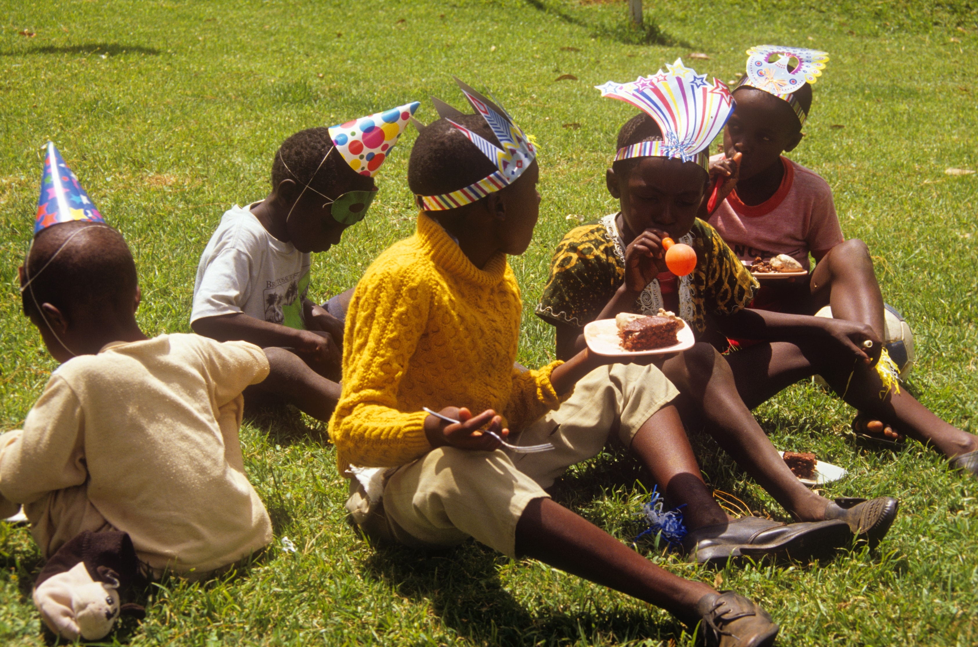 Children celebrating a birthday party on the grass in Kenya