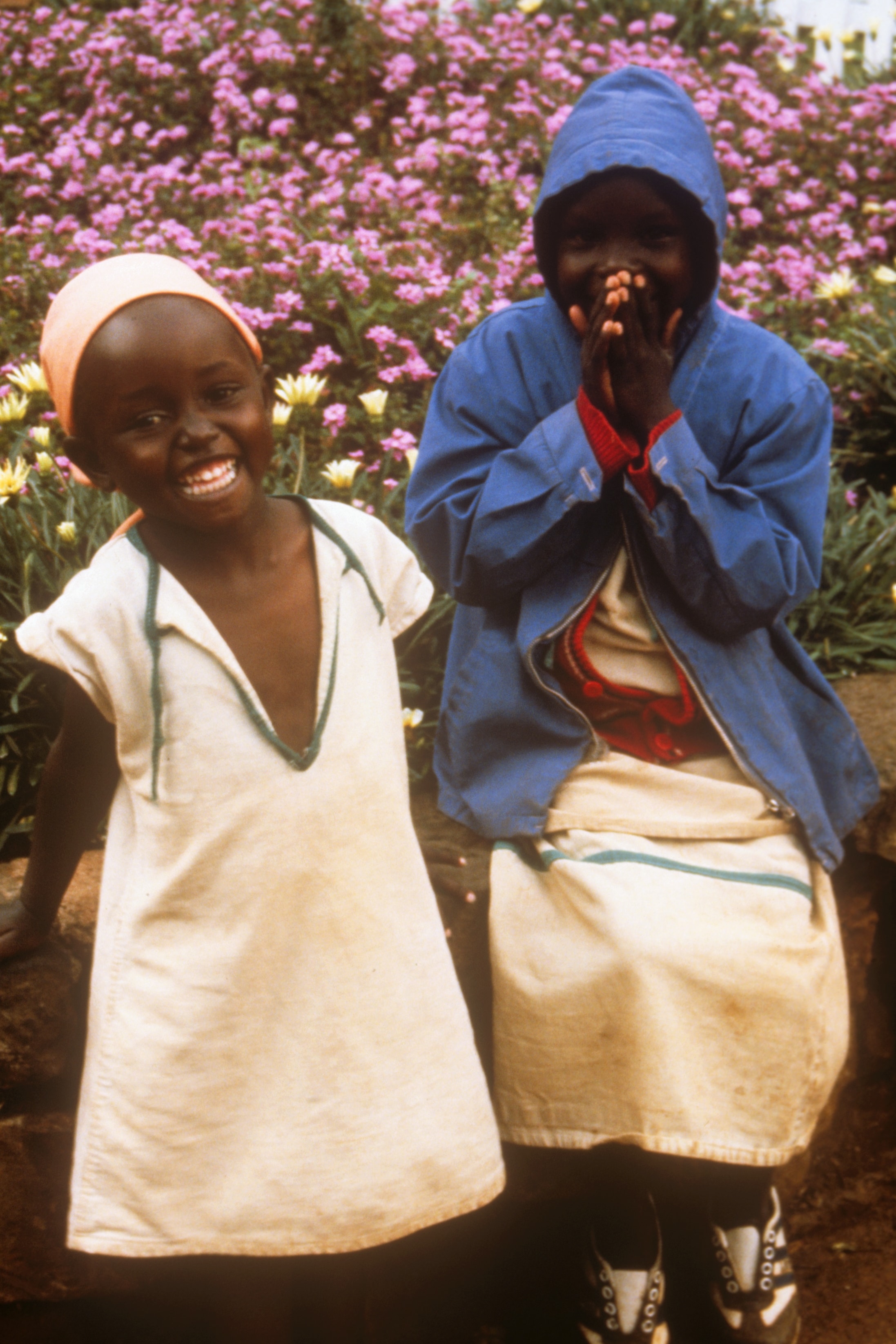 Two children laughing in a flower garden in Kenya