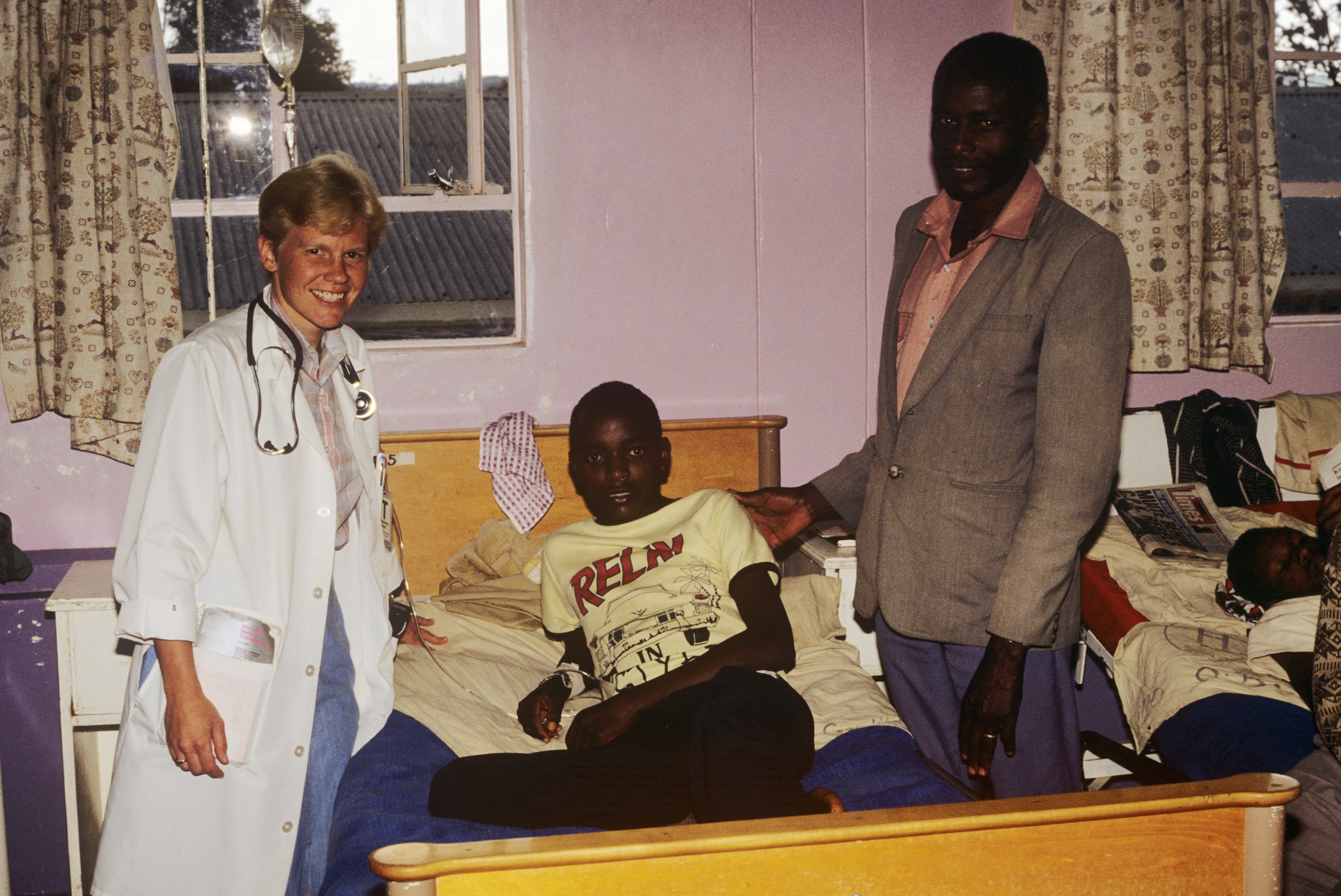 Dr. Susan Vitalis with a young patient and his father in a hospital ward in Kenya