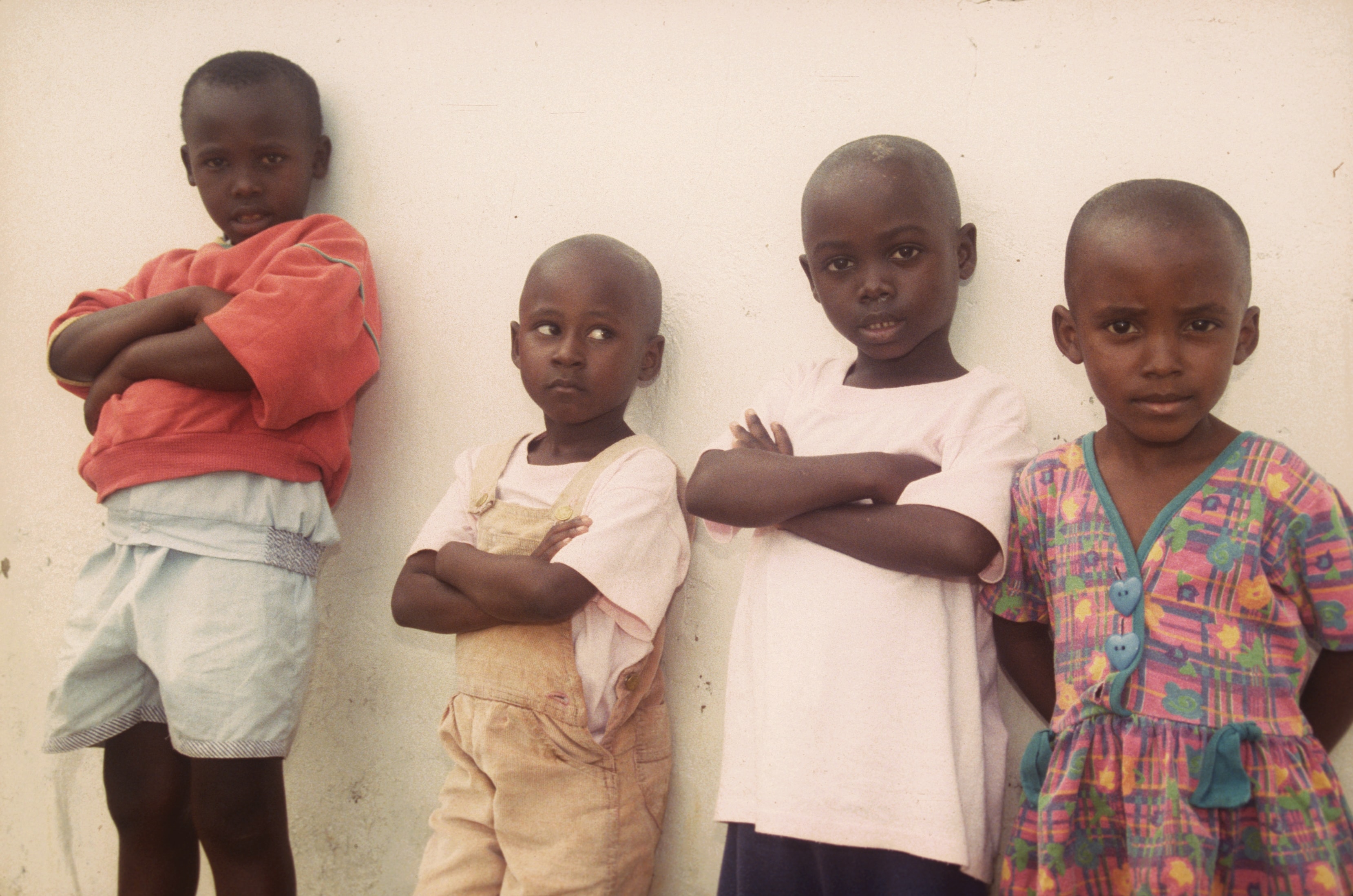 Four children standing against a white wall in Rwanda