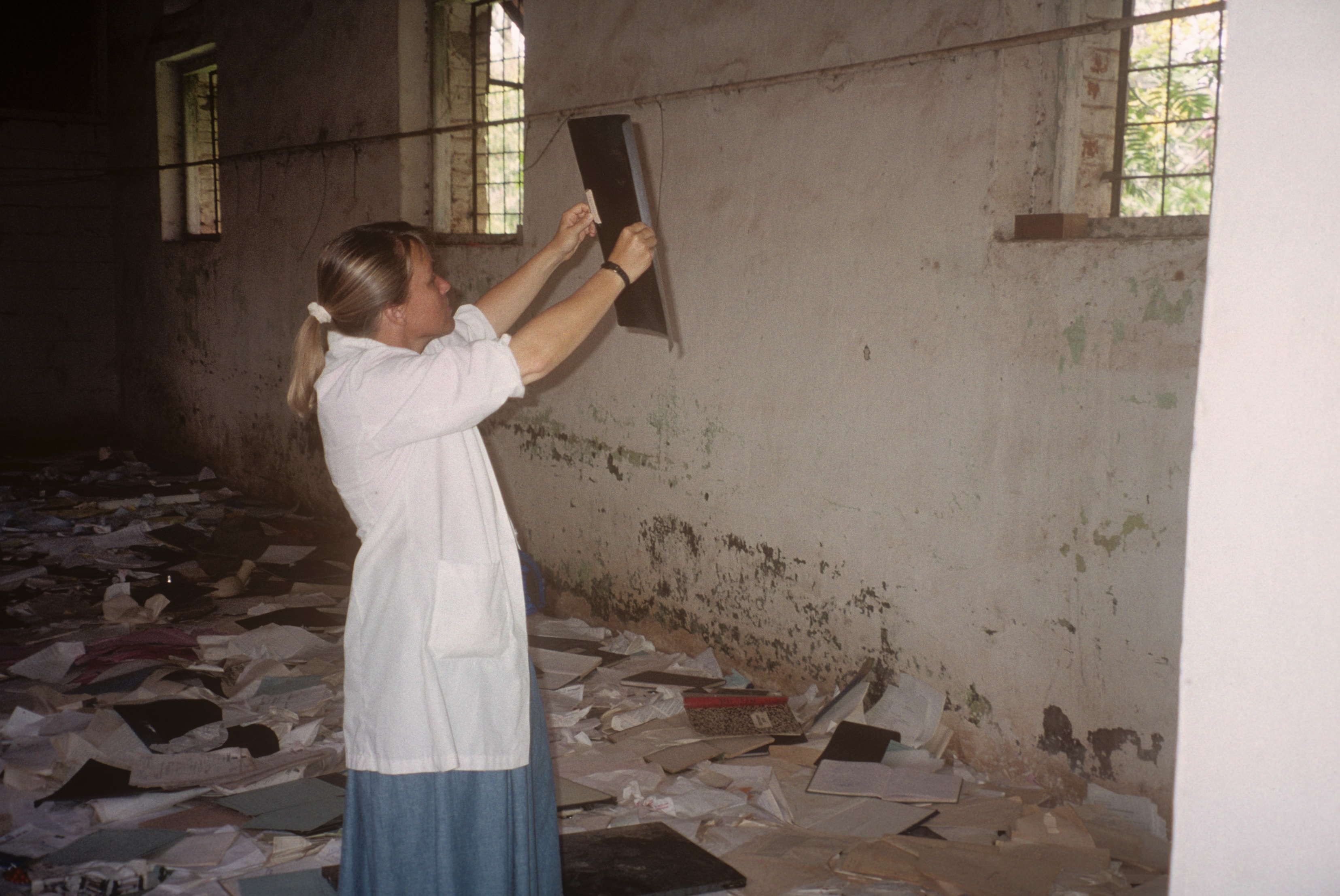 Dr. Susan Vitalis reading an X-ray in a damaged building in Rwanda
