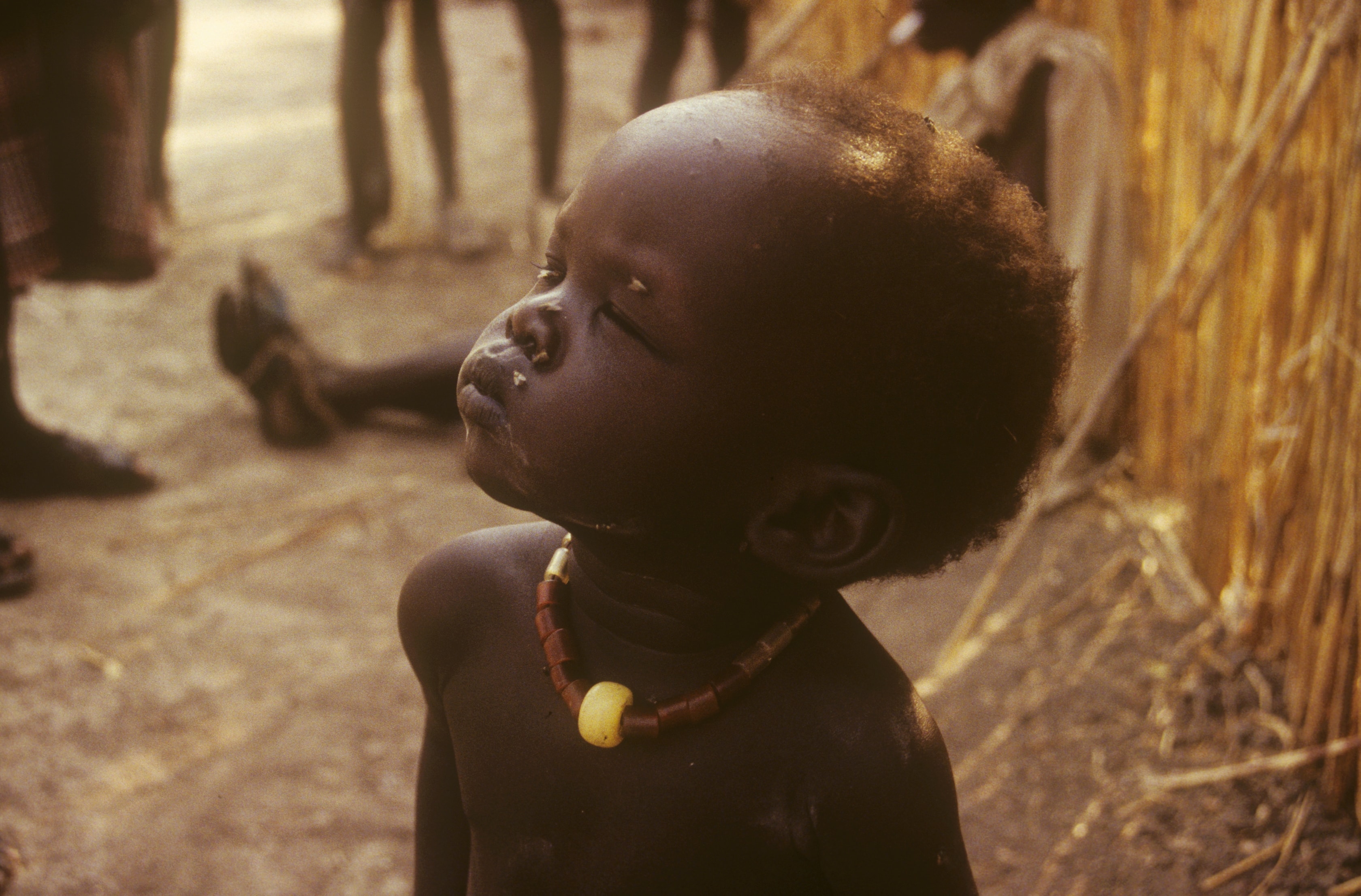 Close-up portrait of a young child wearing a beaded necklace in Sudan