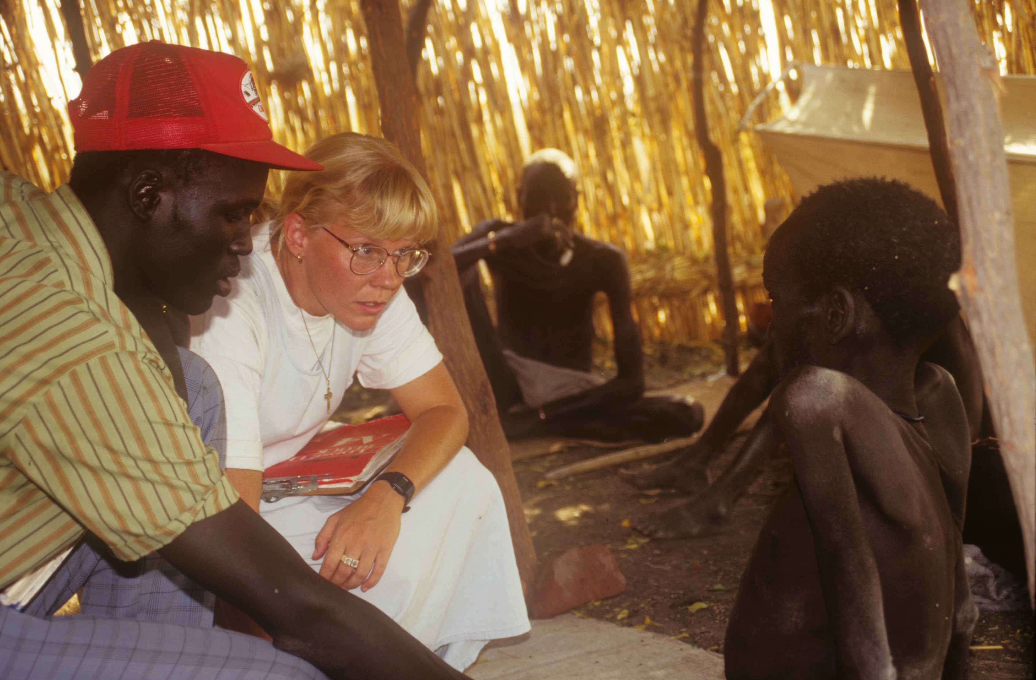Dr. Susan Vitalis consulting with a translator and examining a child in Sudan