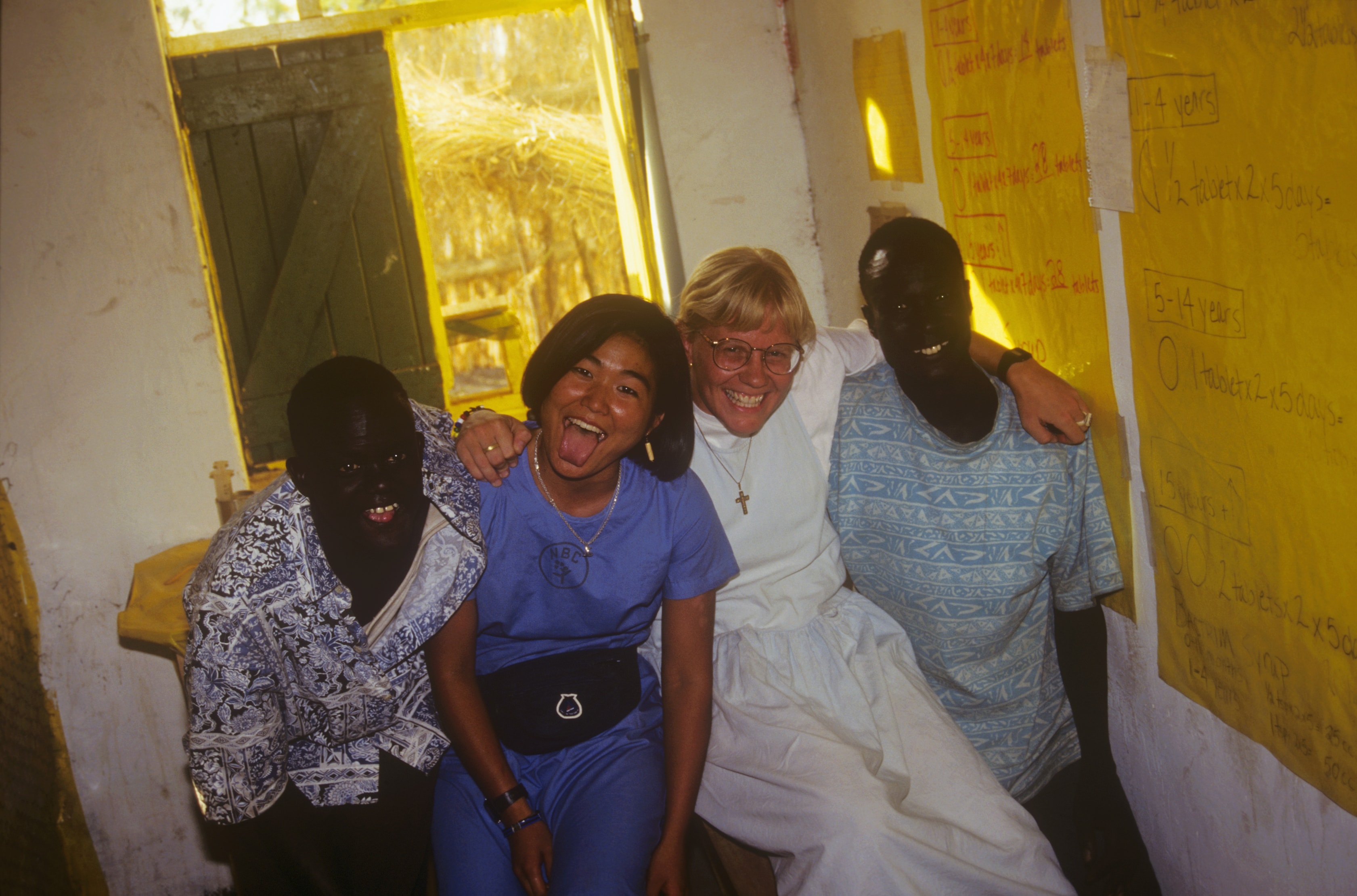 Dr. Susan Vitalis laughing with two Sudanese colleagues and a fellow team member inside a clinic