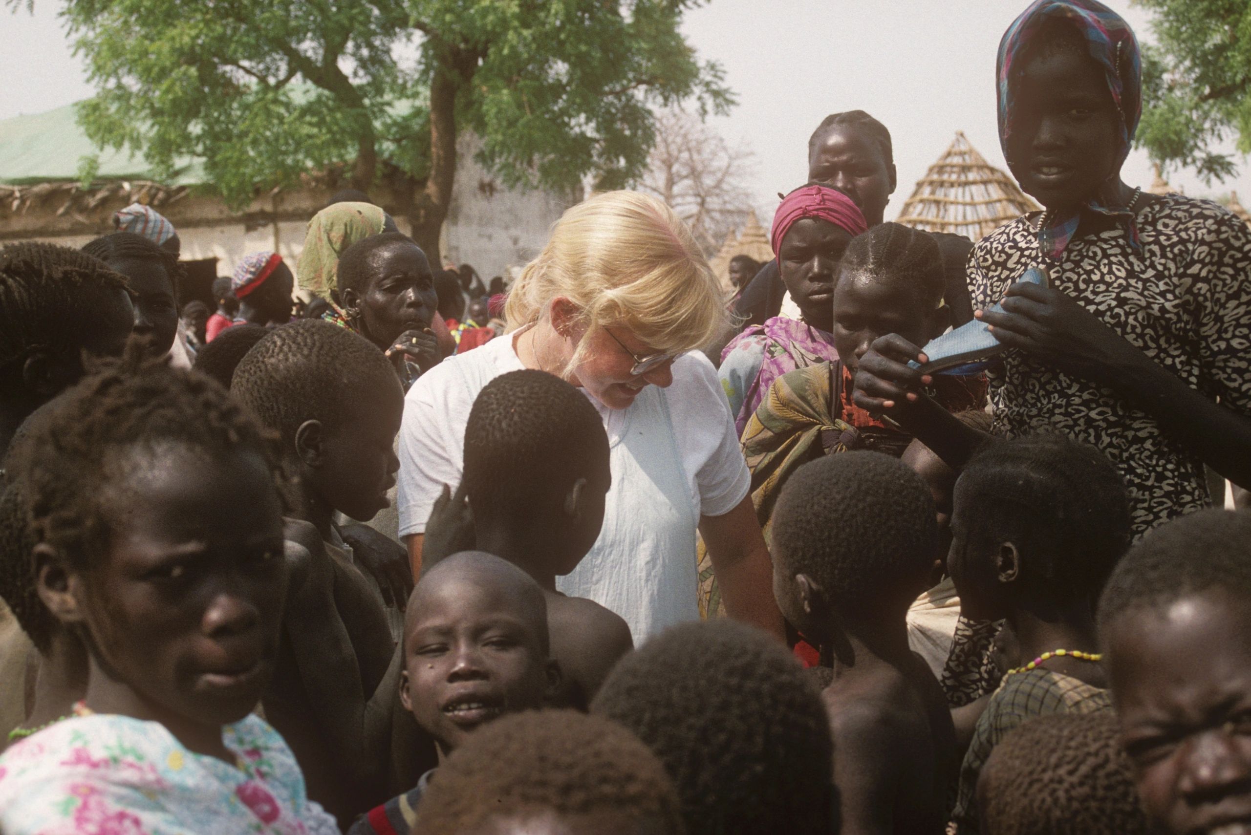 Susan Vitalis surrounded by children in Africa